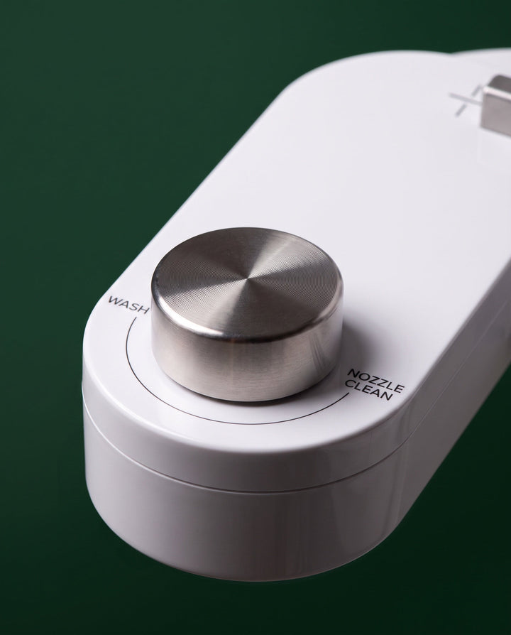 Close-up of the brushed steel control dial, marked Wash and Nozzle Clean